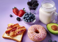 A diversity of foods showcasing the many possibilities for flavour creation: a jug of fresh, creamy milk, fruits and berries, bacon toast, sprinkled doughnut, avocado