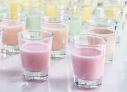 Rows of shot glasses with colourful liquids ready for tasting
