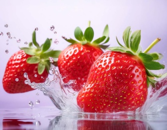 Three strawberries splashing into fresh water