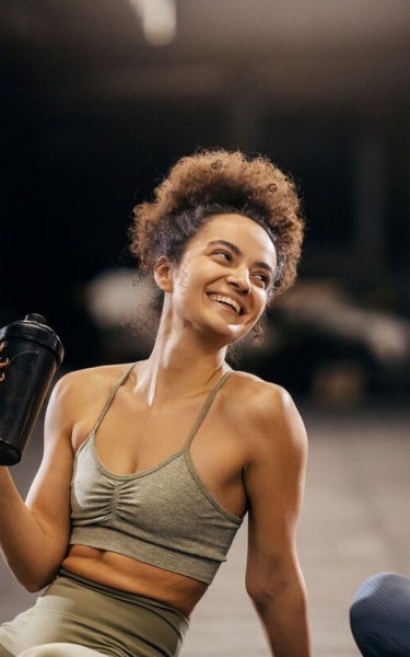 Two women in the gym enjoying the fitness break, both laughing. 