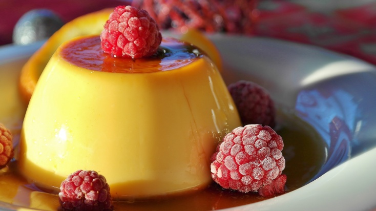 Caramel pudding topped with raspberries.