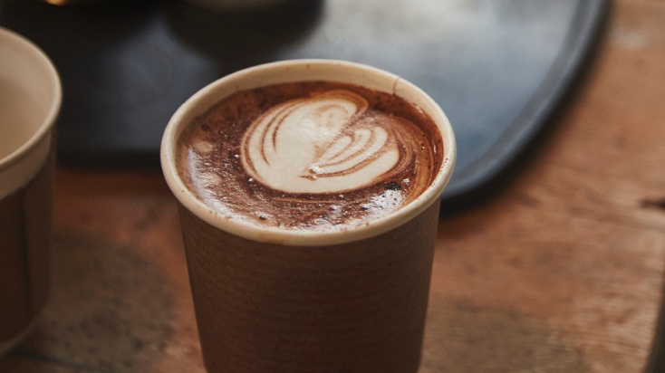 a cup of cappuccino from a vending machine with delicouse creamy foam on top