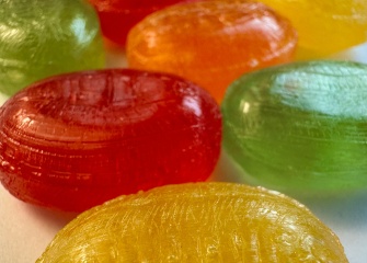 a row of colourful hard booiled candies in yellow, red, green, orange