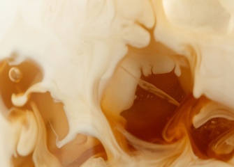 Close up of coffee and milk mixing